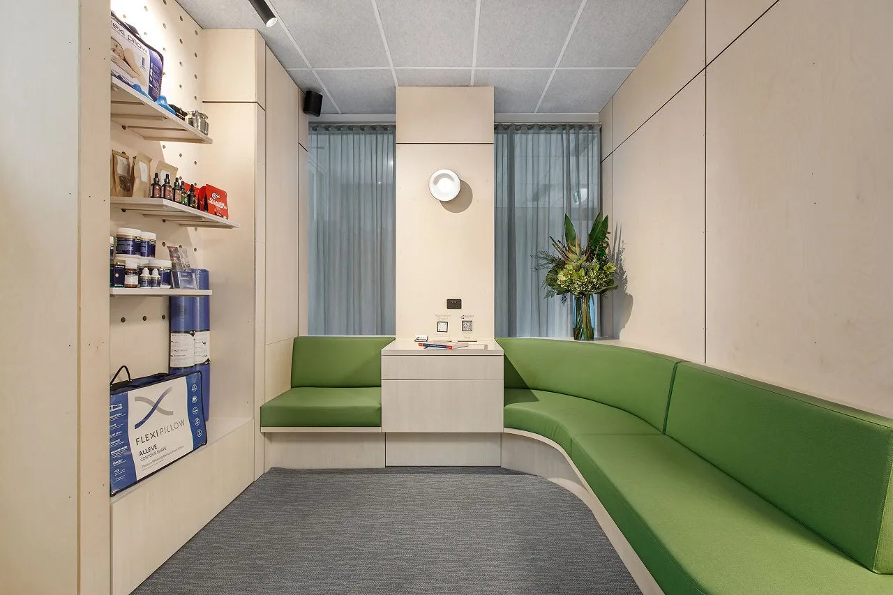 Custom-made Birch Plywood wall panelling in the waiting room with green sofa