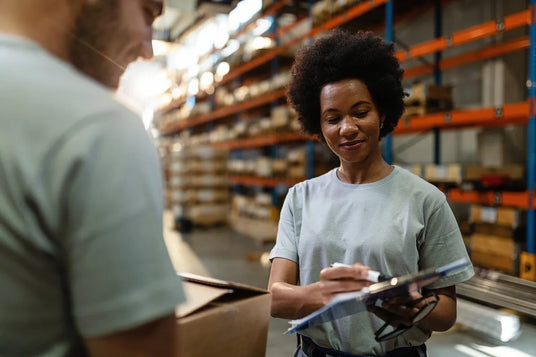 A woman sign documents in a warehouse