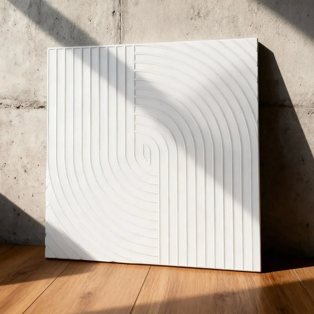 Textured white plywood decorative panel with geometric grooves, leaning against a concrete wall