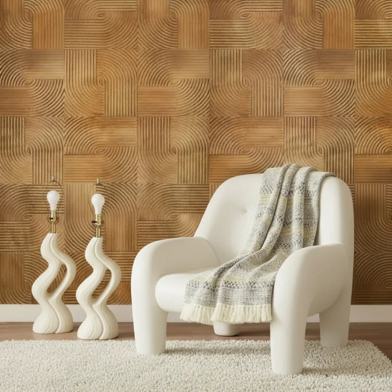 Modern lounge room with plywood wall cladding, sculptural lamps, and a white armchair