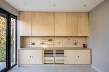 Modern workshop with Baltic birch plywood cabinets, pegboard backsplash, and natural light