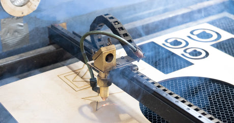 Plywood sheet with cut shapes under the laser cutting machine