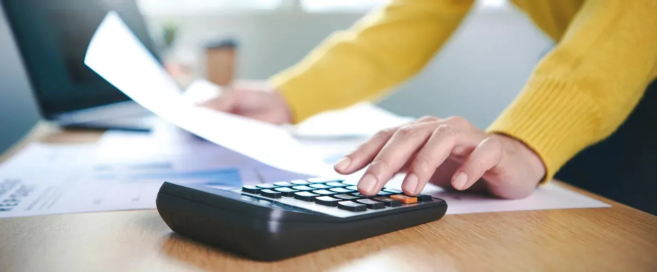 Person using calculator and holding paperwork for plywood or building materials estimate