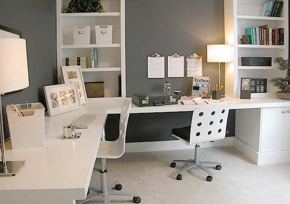 Modern home office with white desk, built-in shelves, and organized workspace