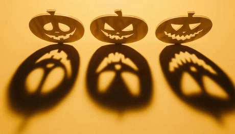 Laser-cut plywood Halloween pumpkin decorations casting spooky shadows