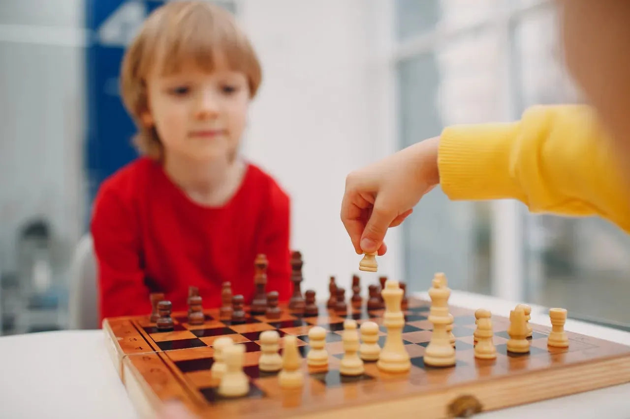 Kids play chess on the plywood chessboard