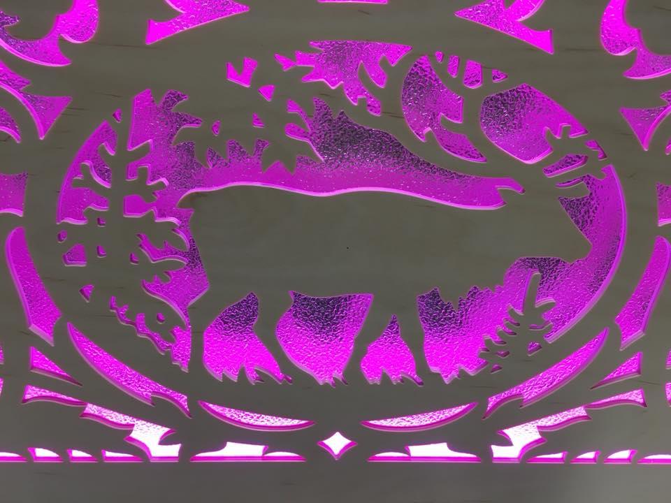 Decorative plywood panel with a carved deer silhouette and purple LED backlighting
