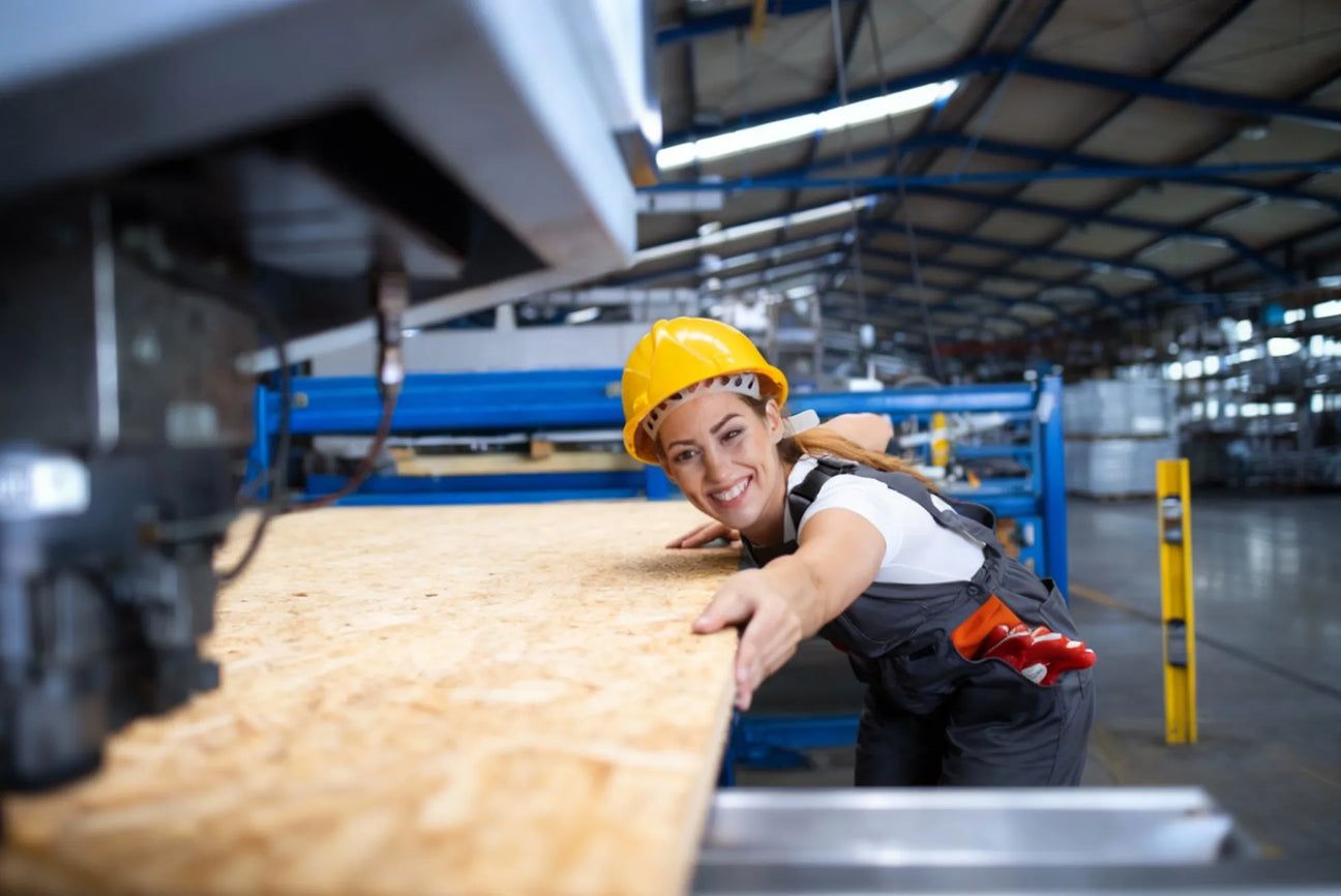 Smiling plywood factory worker with a plywood sheet