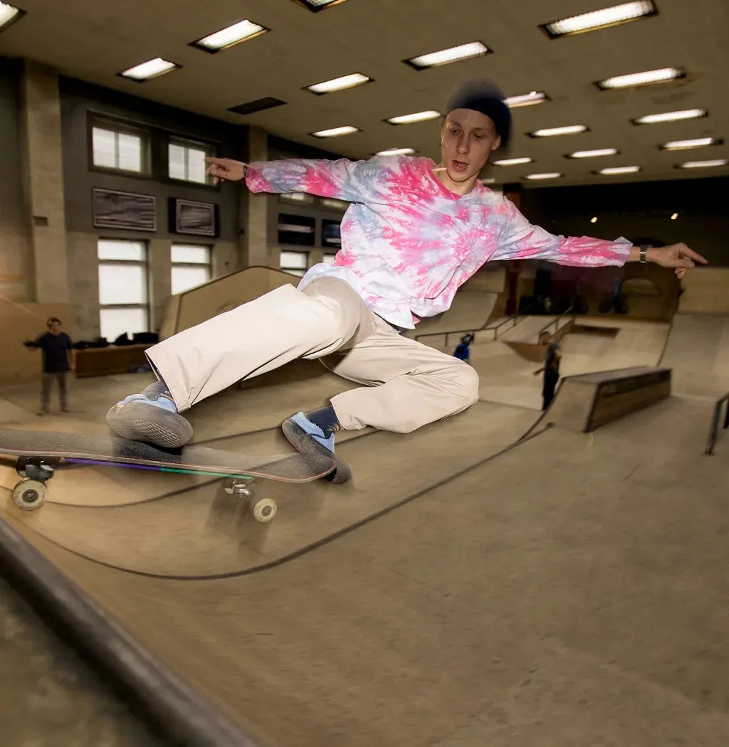 Young man jumps on the plywood skate ramp