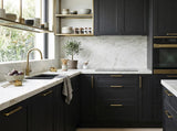 Modern kitchen with black cabinets made with Black Oak Timber Veneer Panel A/B UV-Coated, marble countertops, and gold fixtures - Ply Online