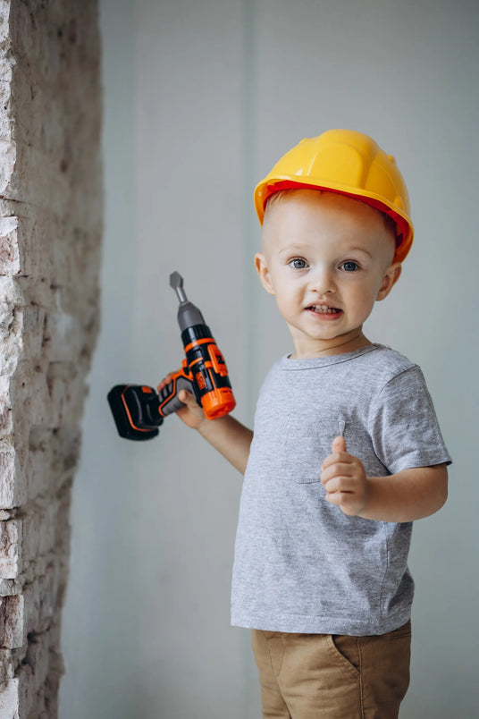 Cute little boy with toy building tools