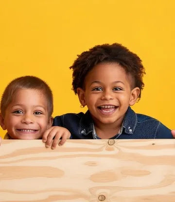 Two children holding a plywood board against a yellow background